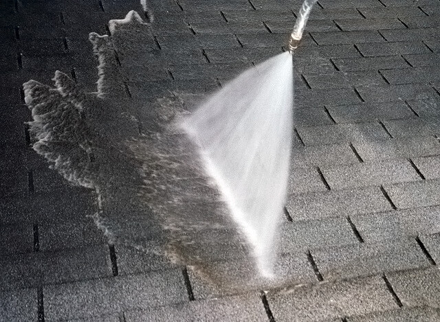 Roof being power washed as part of Greer services.
