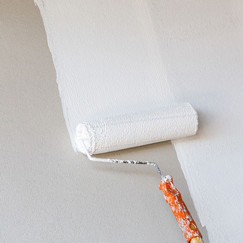 Painting contractors. Commercial Painters. White paint being rolled onto a wall. 