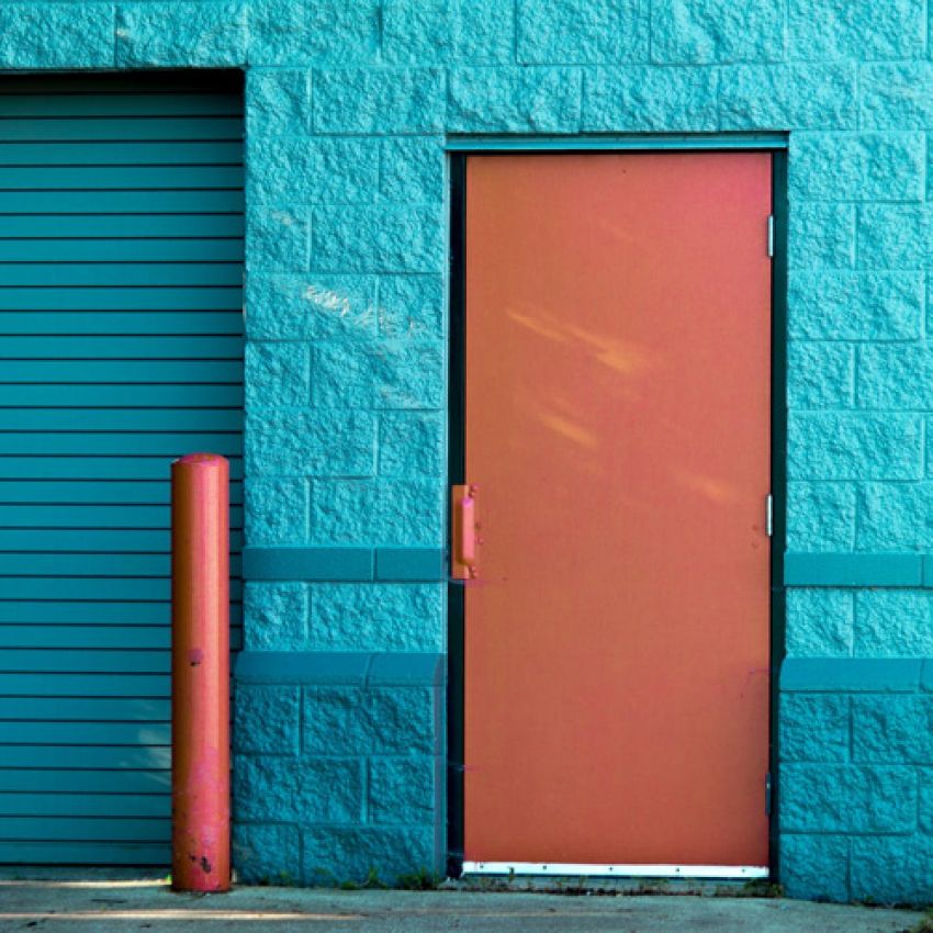Painting contractors. Commercial Painters. Orange painted door on a blue wall. 