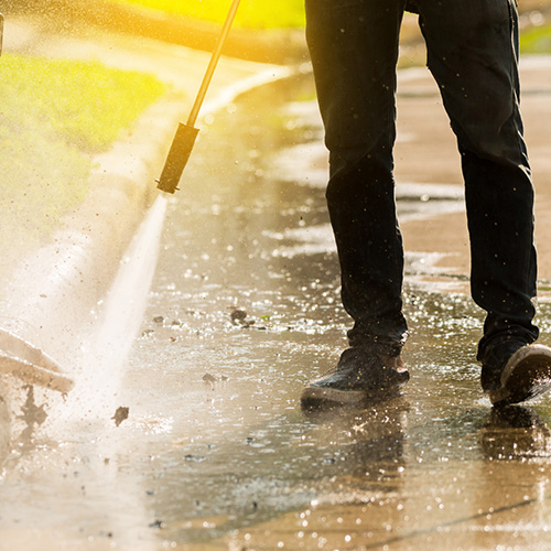 Painting contractors. Commercial Painters. Man Power washing outside.